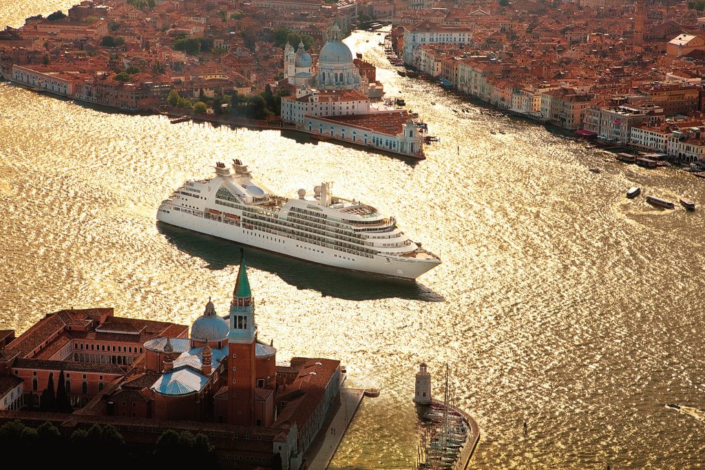 Umweltverschmutzung durch Abgase und Übertourismus durch große Kreuzfahrtschiffe - die Kreuzfahrtbranche gefährdet das Weltkulturerbe warnt die UNESCO. Jetzt soll Venedig wegen dieser Gefährdung in die schwarze Liste der gefährdeten Weltkulturerbestätten aufgenommen werden.